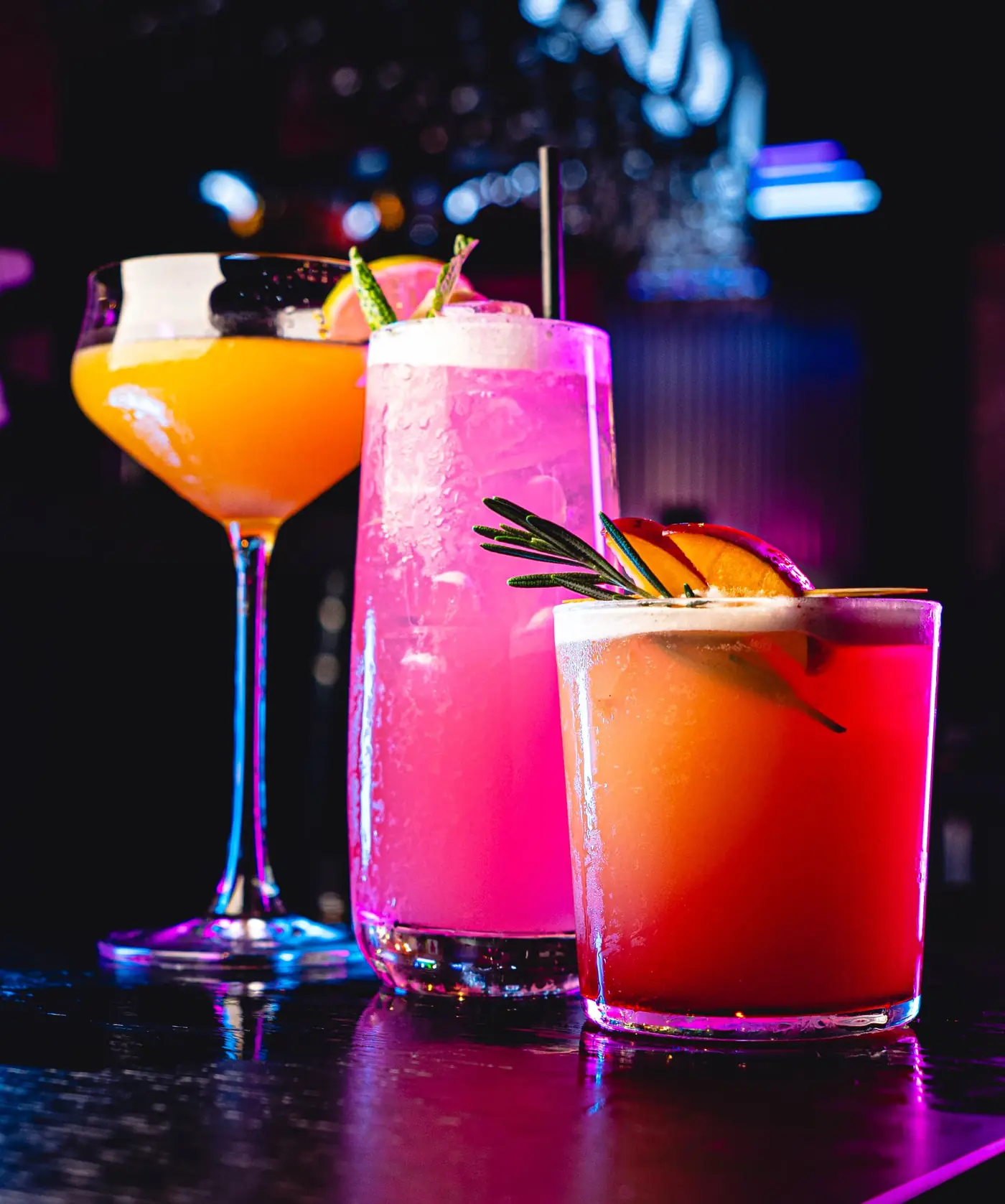 Three signature cocktails — pink, peach and citrus — on the bar at Seafood City Birmingham
